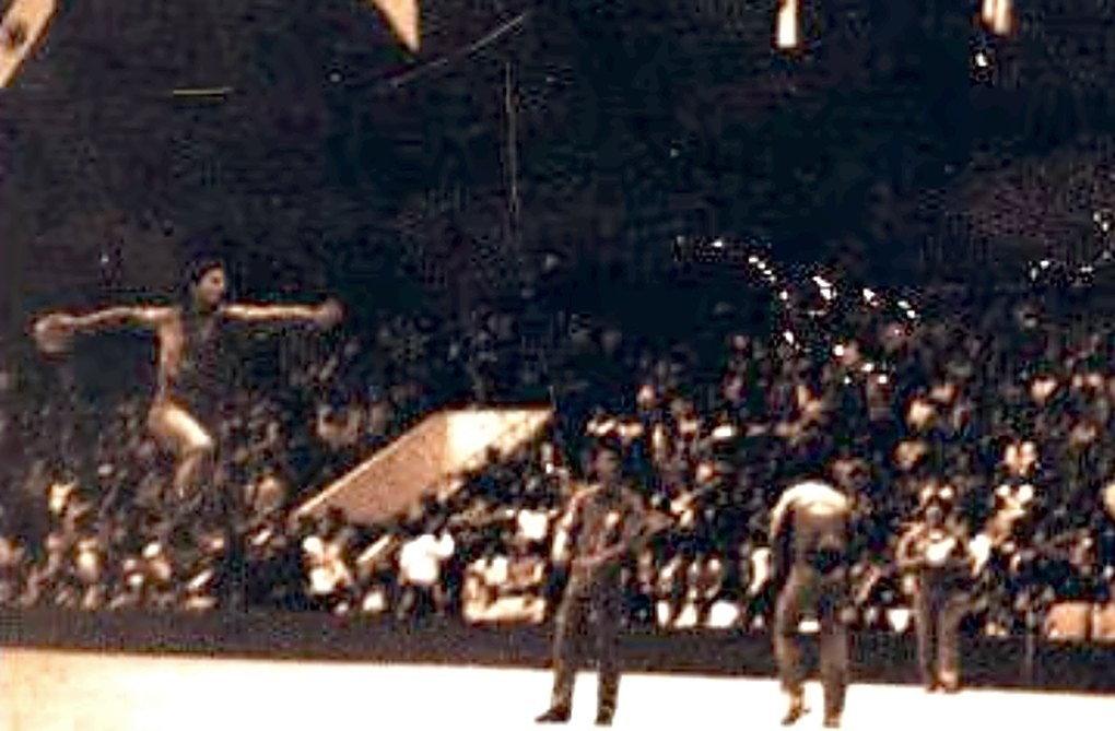 Edgar Hubner saltando para o arremesso em partida de handebol, em ginásio lotado